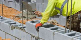 WSD Implements Tightened Security Measures at Olivees Reservoir On a construction site, a mason is in the process of erecting a wall of aerated concrete blocks